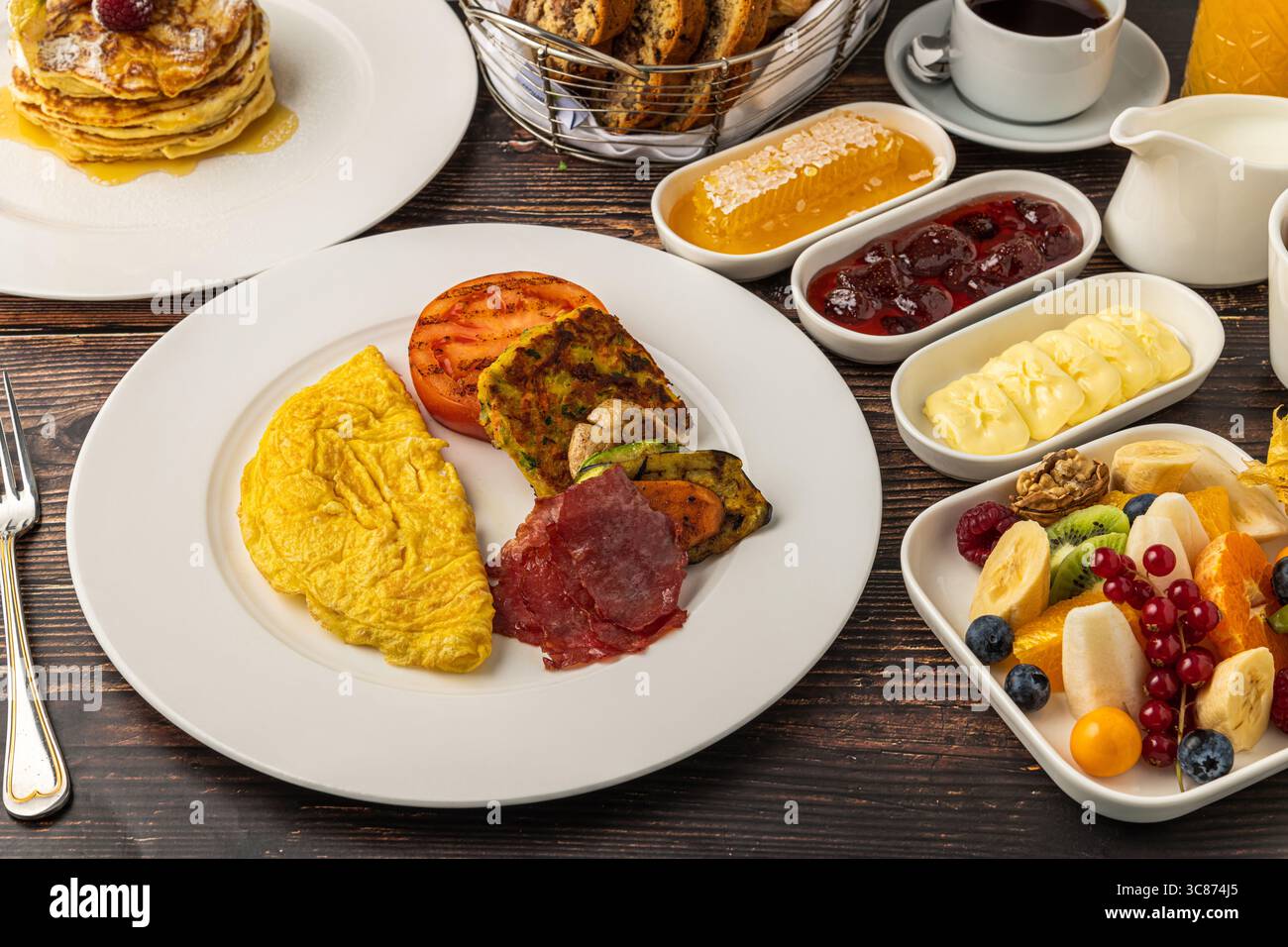 Deliziosa colazione con pancake, omelette, croissant e frutta Foto Stock