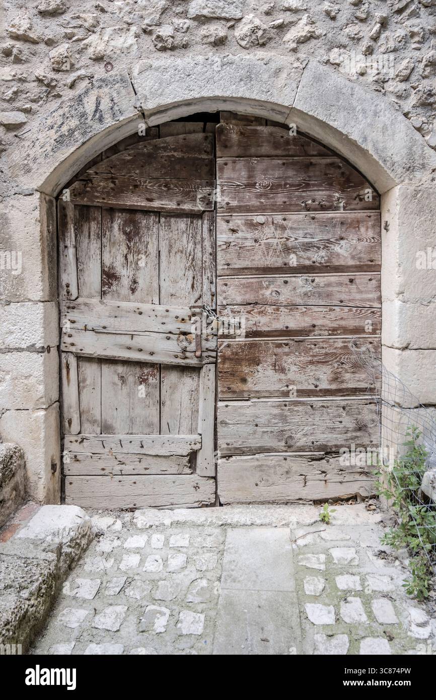 Paesaggio urbano con pittoresco portale in legno presso lo storico paesino collinare, fotografato dalla luce estiva a Santo Stefano di Sessanio, l'Aquila, A. Foto Stock