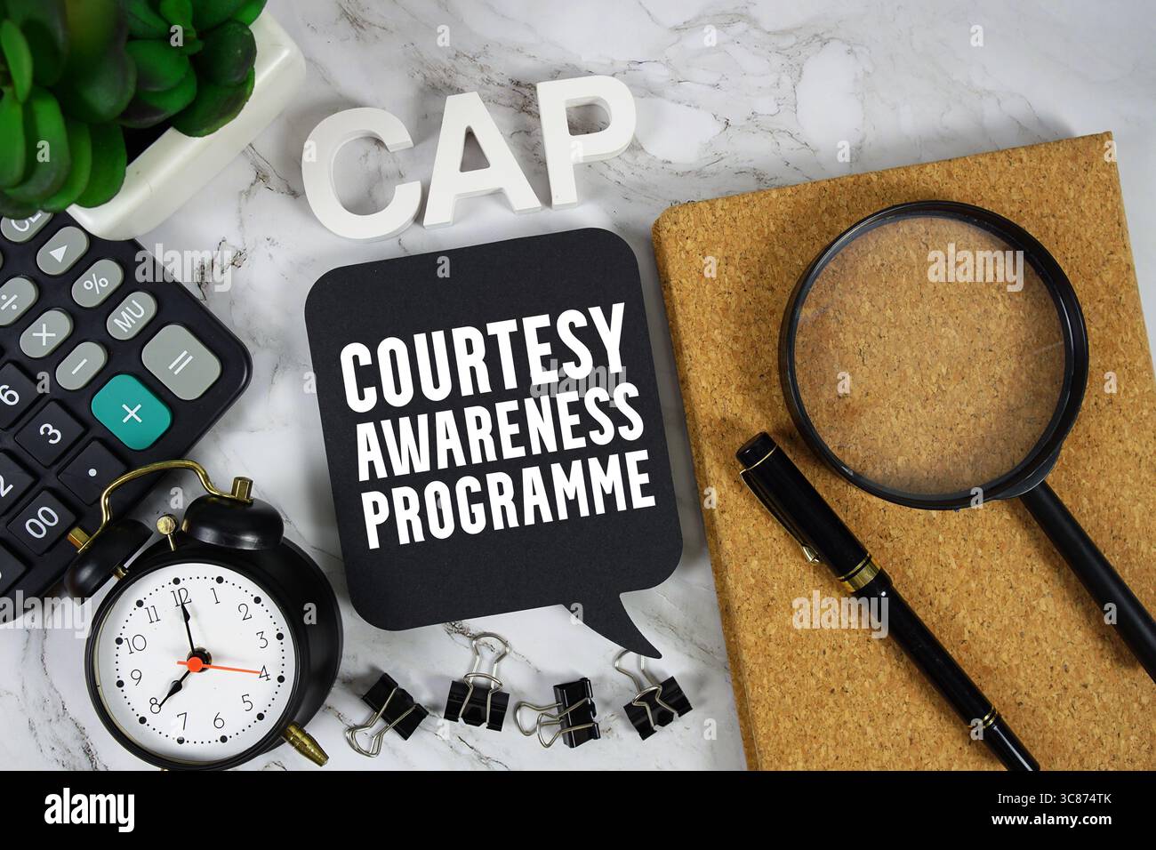 CAP testo del programma di sensibilizzazione per gentile concessione con calcolatrice, sveglia e lente di ingrandimento su sfondo in marmo Foto Stock
