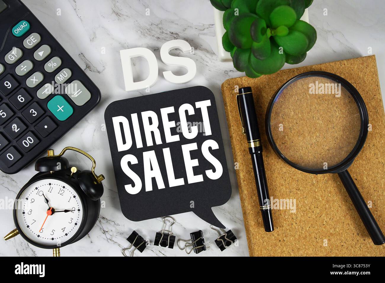 DS Direct Sales text con calcolatrice, sveglia e lente d'ingrandimento su sfondo in marmo Foto Stock