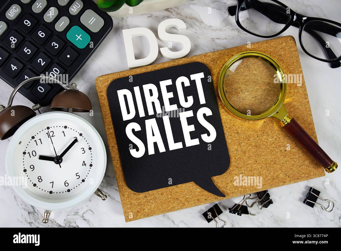DS Direct Sales text con calcolatrice, sveglia e lente d'ingrandimento su sfondo in marmo Foto Stock