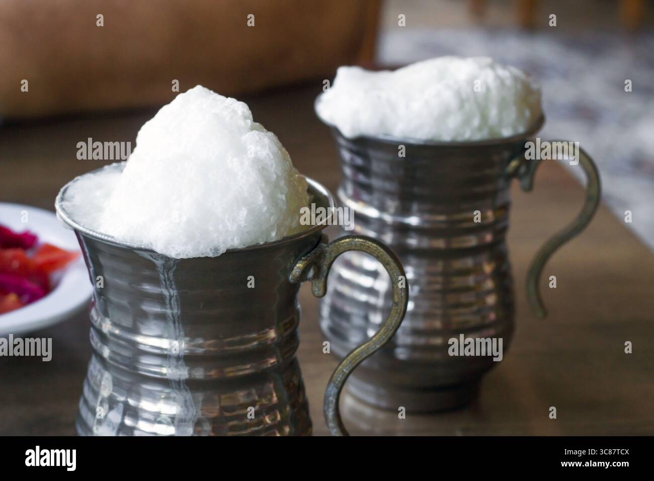 Tradizionale siero di latte turco schiumoso, ayran in una tazza di rame Foto Stock