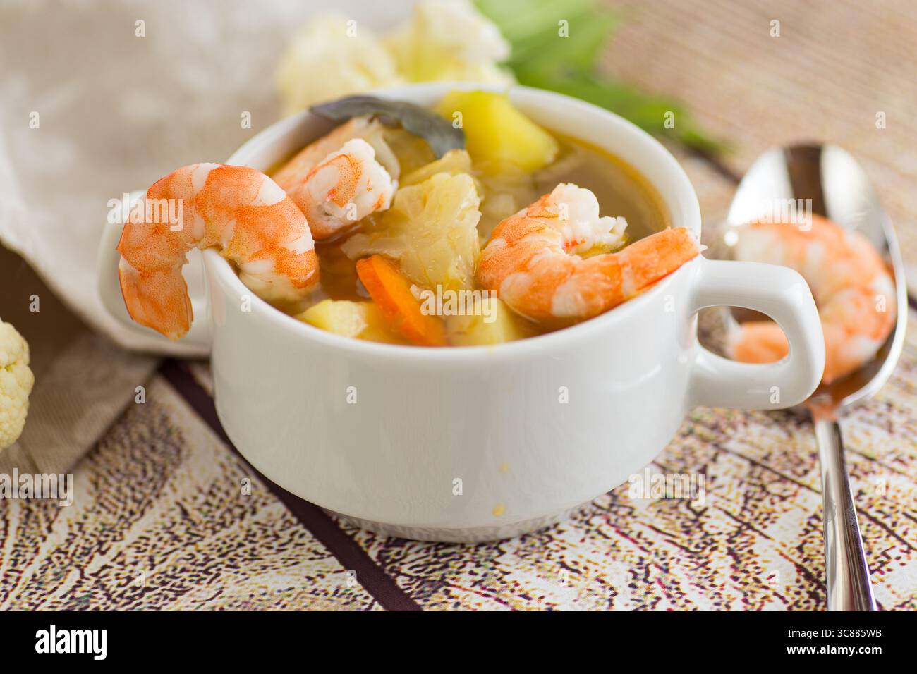 Zuppa leggera di proteine con gamberi, patate e basilico. Foto Stock