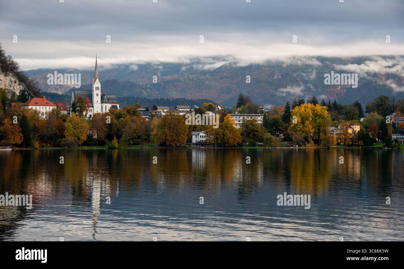 Vista panoramica del lago con st. La chiesa parrocchiale di Martin e il colorato fogliame autunnale di Bled, slovenia Foto Stock