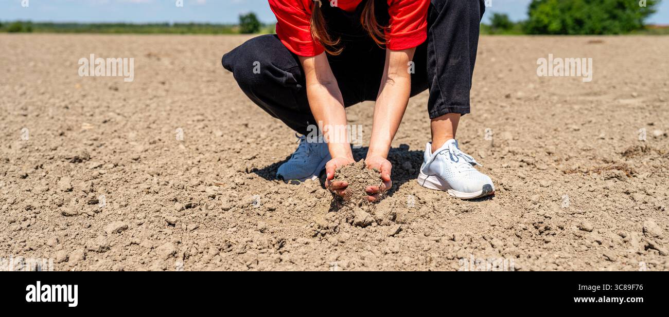 Donna agronomo che ispeziona la qualità del suolo sui terreni agricoli per un'agricoltura sostenibile Foto Stock