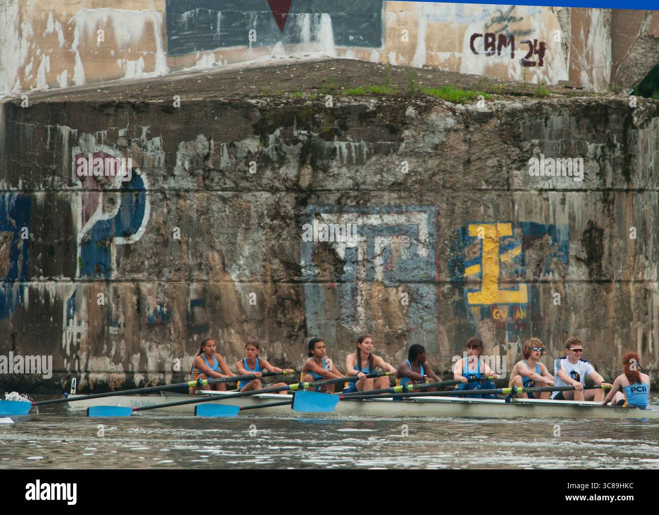 I canottieri della Philadelphia City Rowing passano davanti ai moli graffitizzati del Columbia Bridge durante la Philadelphia Youth Regatta. Foto Stock