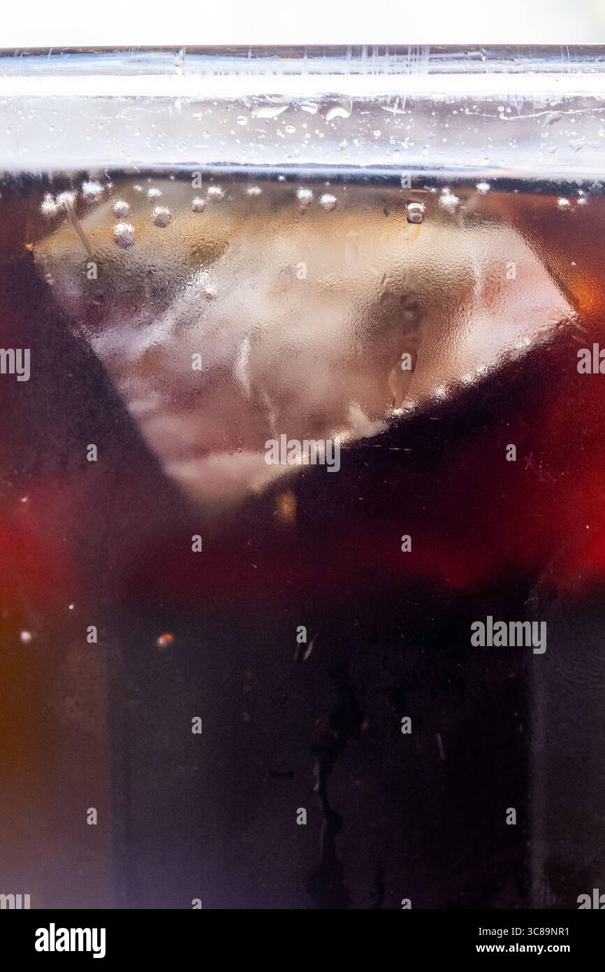 Primo piano di cola frizzante con Ice Cube e bollicine Foto Stock