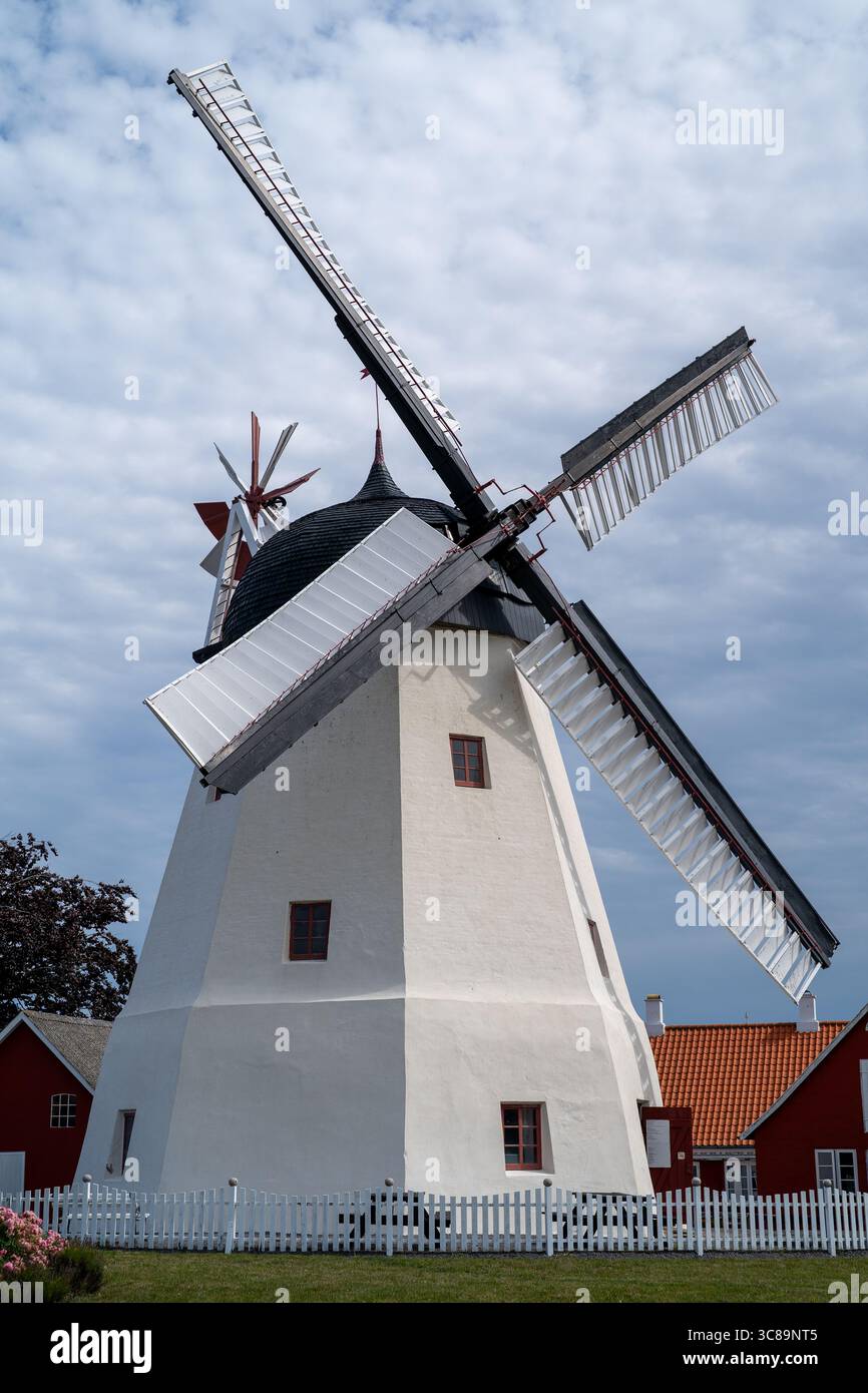 Classico mulino a vento danese con vele in legno e fattorie rosse Foto Stock