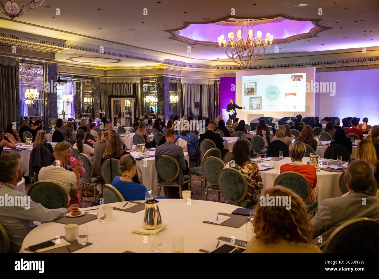 I partecipanti alle conferenze sono seduti attorno ai tavoli Foto Stock