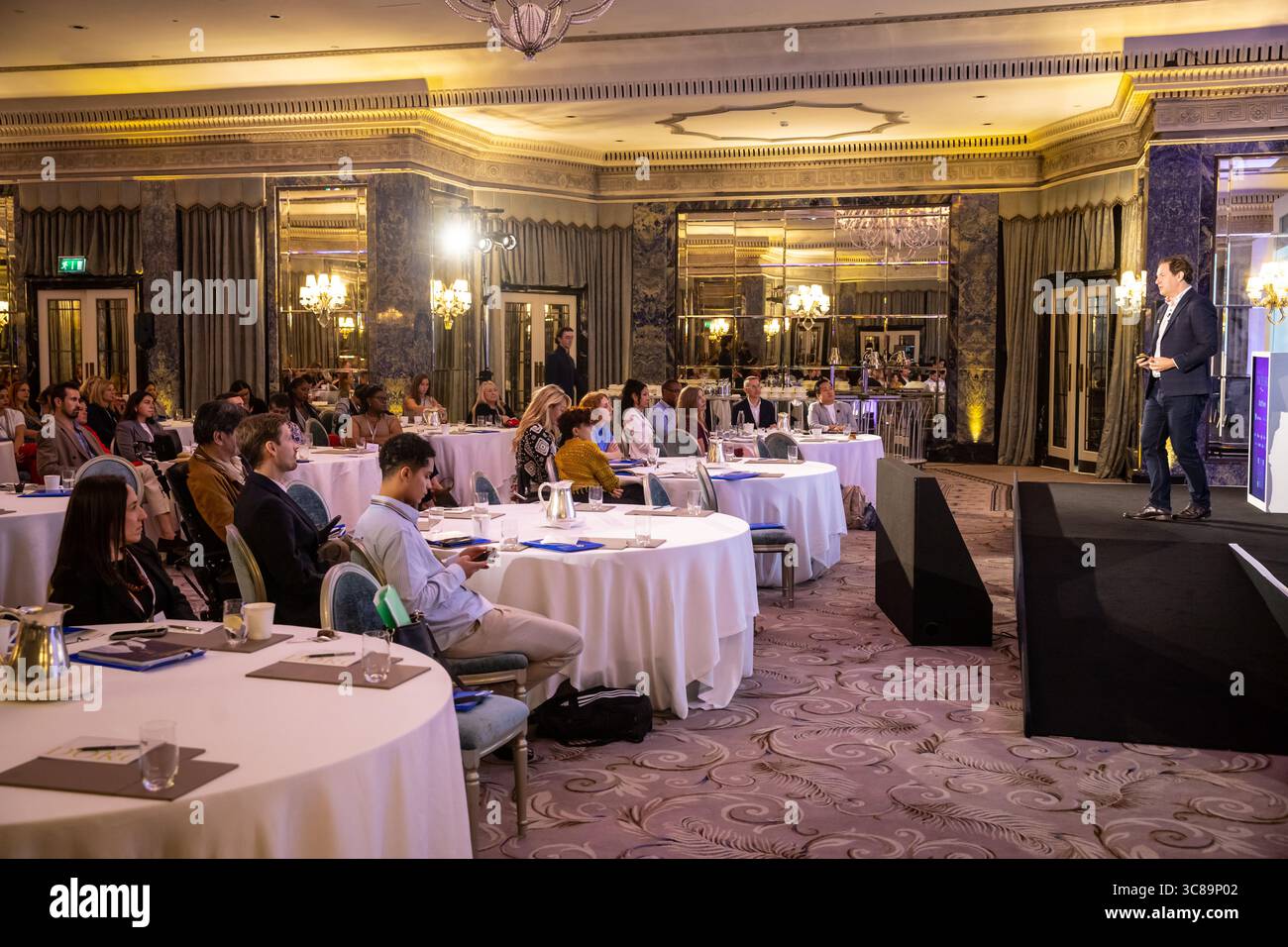 I partecipanti alle conferenze sono seduti attorno ai tavoli Foto Stock