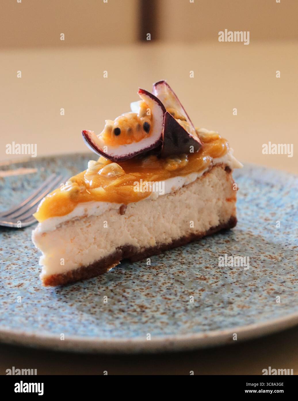 Realizzata con una semplice crosta di biscotti graham e ripieno di cheesecake, la cheesecake al frutto della passione è incredibilmente bella Foto Stock