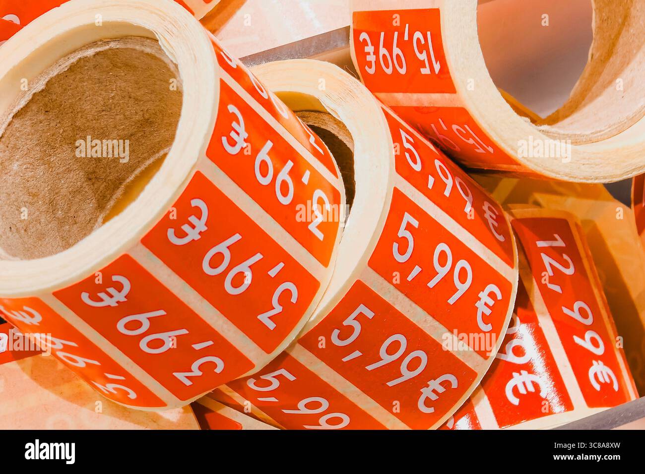Vendite stagionali. Rotoli di adesivi rossi scontati nel negozio di moda. Cartellini promozionali per la vendita di abbigliamento Foto Stock