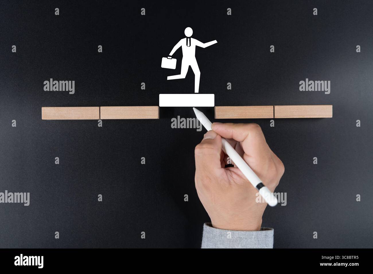 Ponte per disegnare a mano per aiutare l'uomo d'affari ad attraversare lo spazio su blocchi di legno su sfondo nero. Simbolo della risoluzione dei problemi, strategia aziendale, successo planni Foto Stock