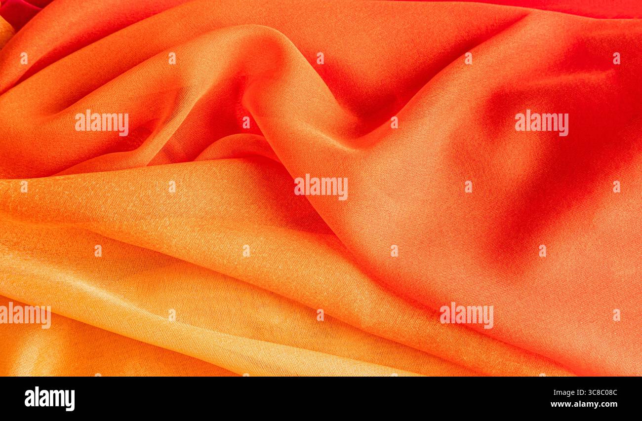 Splendido sfondo natalizio in tessuto di seta arancione brillante. morbide pieghe delicate della trama del tessuto. Layout per la progettazione. Una copia dello spazio. banner Foto Stock