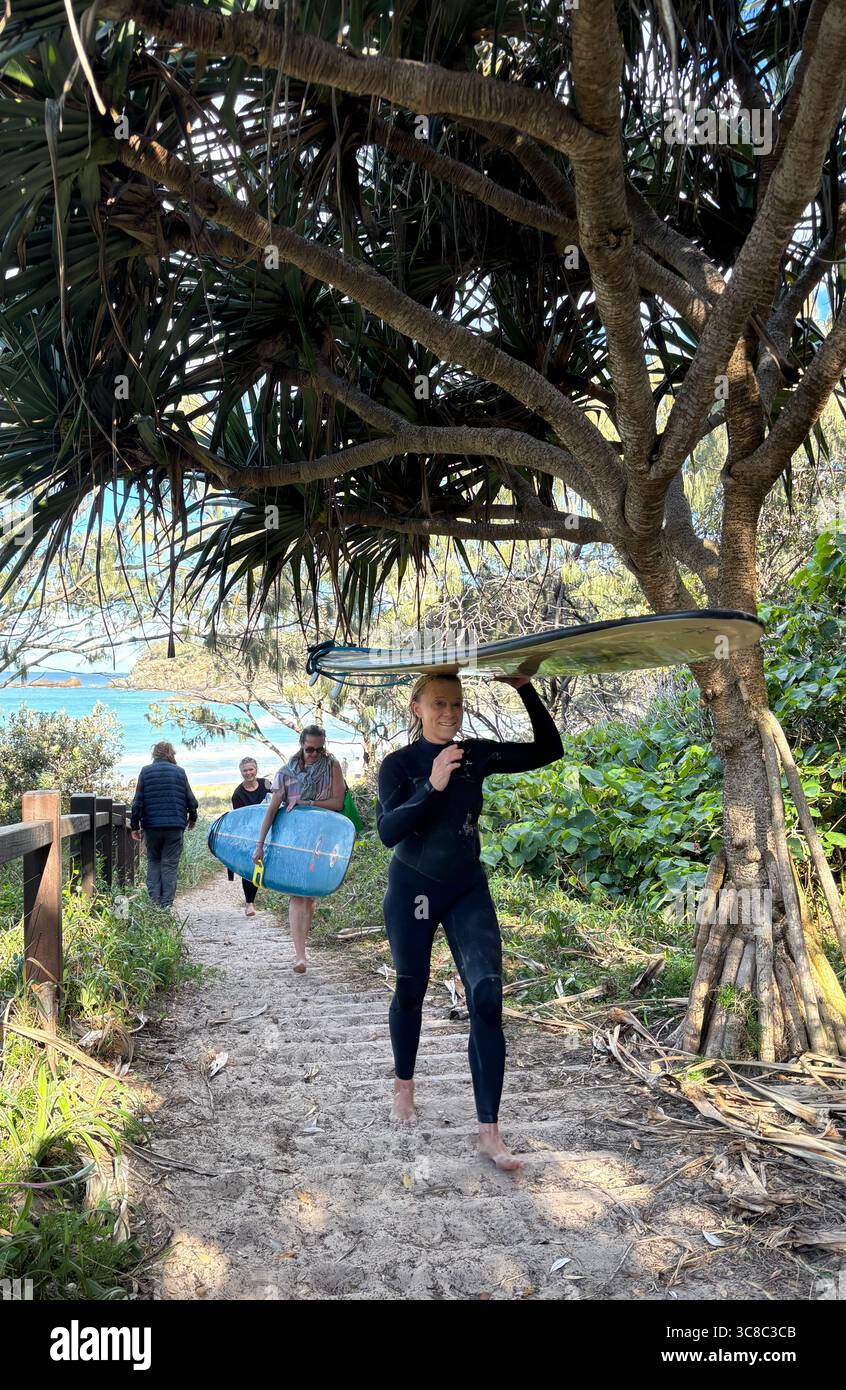 Surfisti donne che trasportano tavole da surf, Alexandria Bay, Noosa National Park, Queensland, Australia. No MR o PR Foto Stock