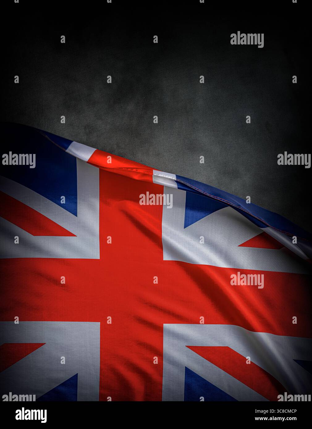 La bandiera del Regno Unito Union Jack ondeggia orgogliosamente su uno sfondo scuro e strutturato Foto Stock