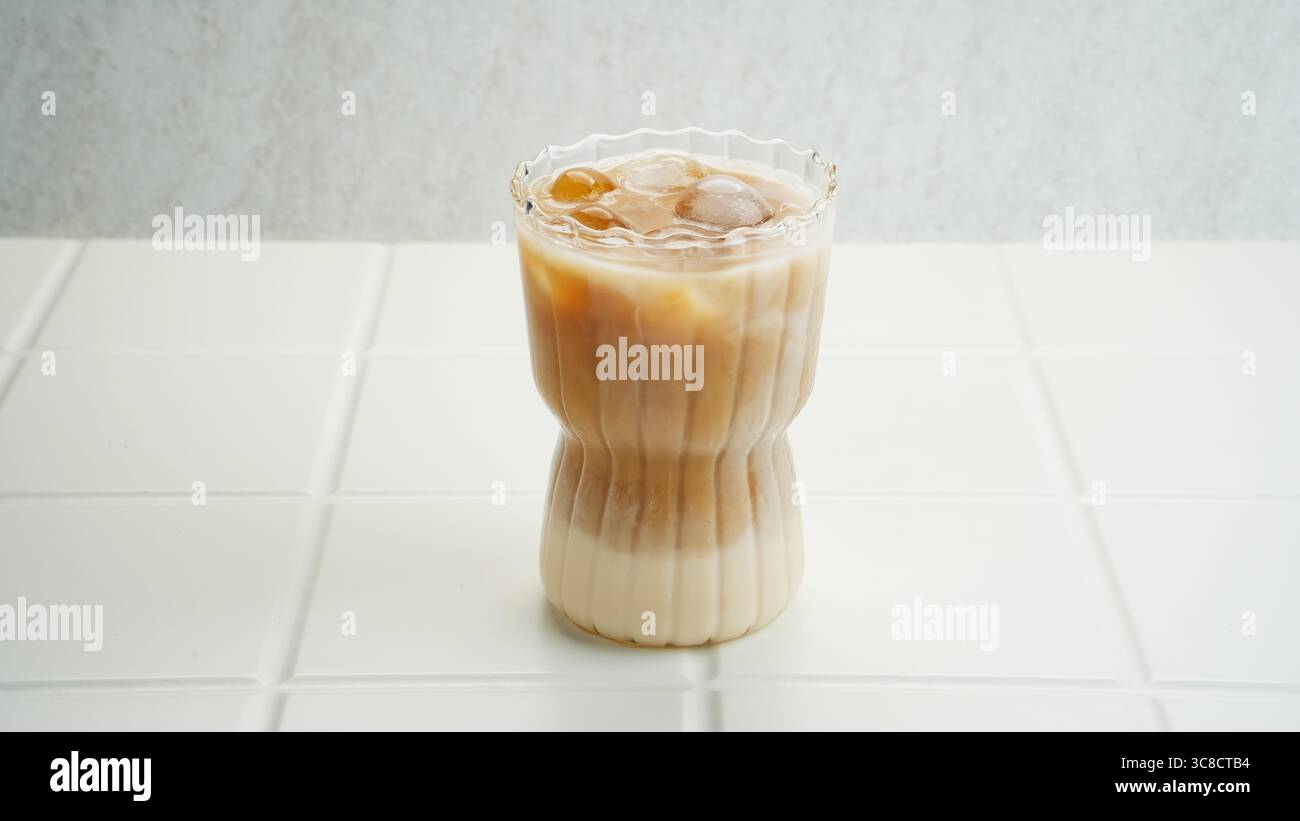 Caffè ghiacciato latte su sfondo bianco/versare caffè nella bevanda a base di latte freddo Foto Stock