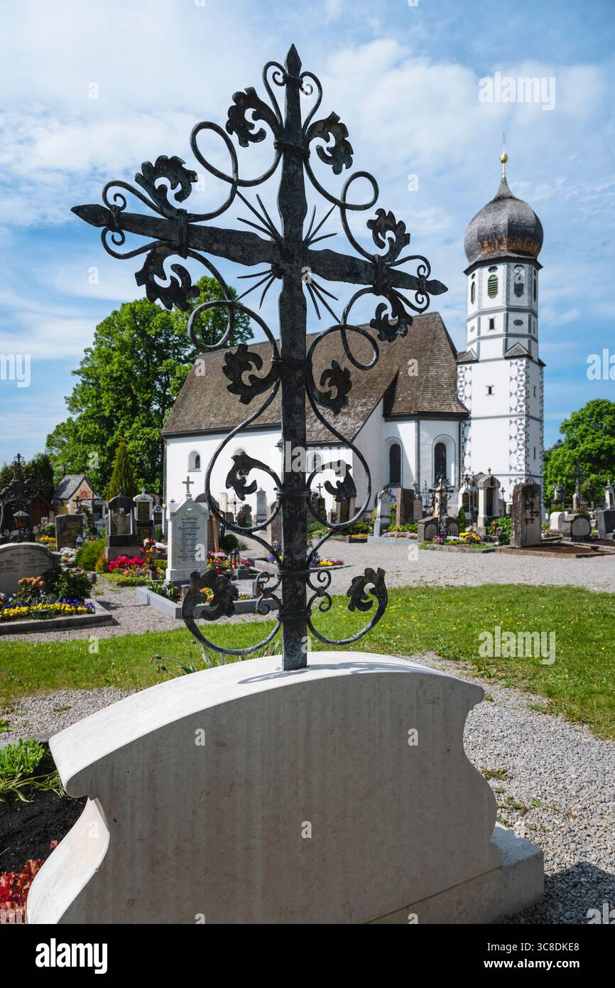 Tombe nel cimitero di fronte alla chiesa bianca di protezione di Santa Maria a Fischbachau, Baviera, Germania Foto Stock