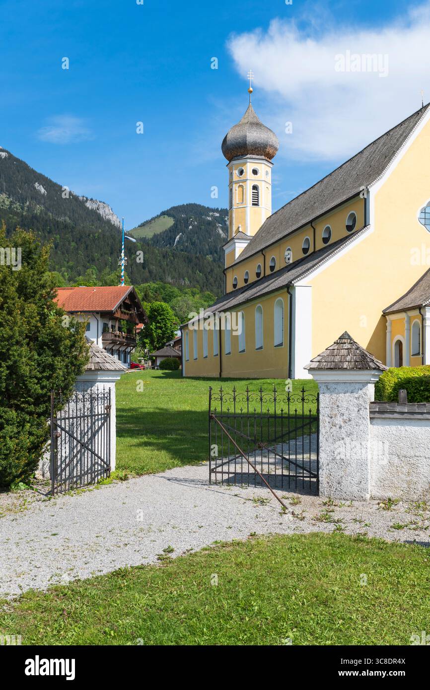 Cancello in ferro battuto all'ingresso del cimitero sulla strada per la chiesa di San Martino a Fischbachau sullo sfondo di una montagna, Baviera, Germania Foto Stock