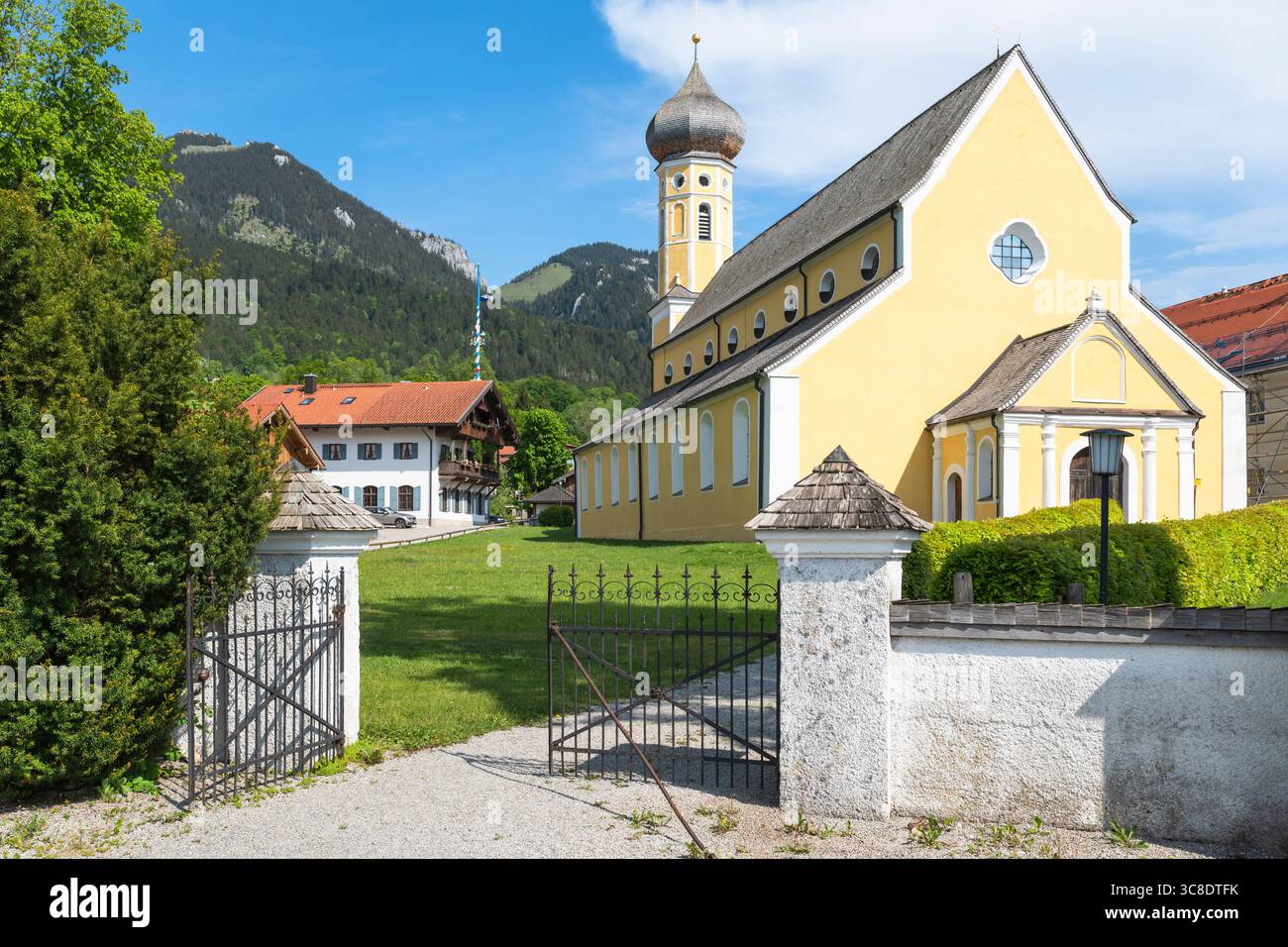 Cancello in ferro battuto all'ingresso del cimitero sulla strada per la chiesa di San Martino a Fischbachau sullo sfondo di una montagna, Baviera, Germania Foto Stock