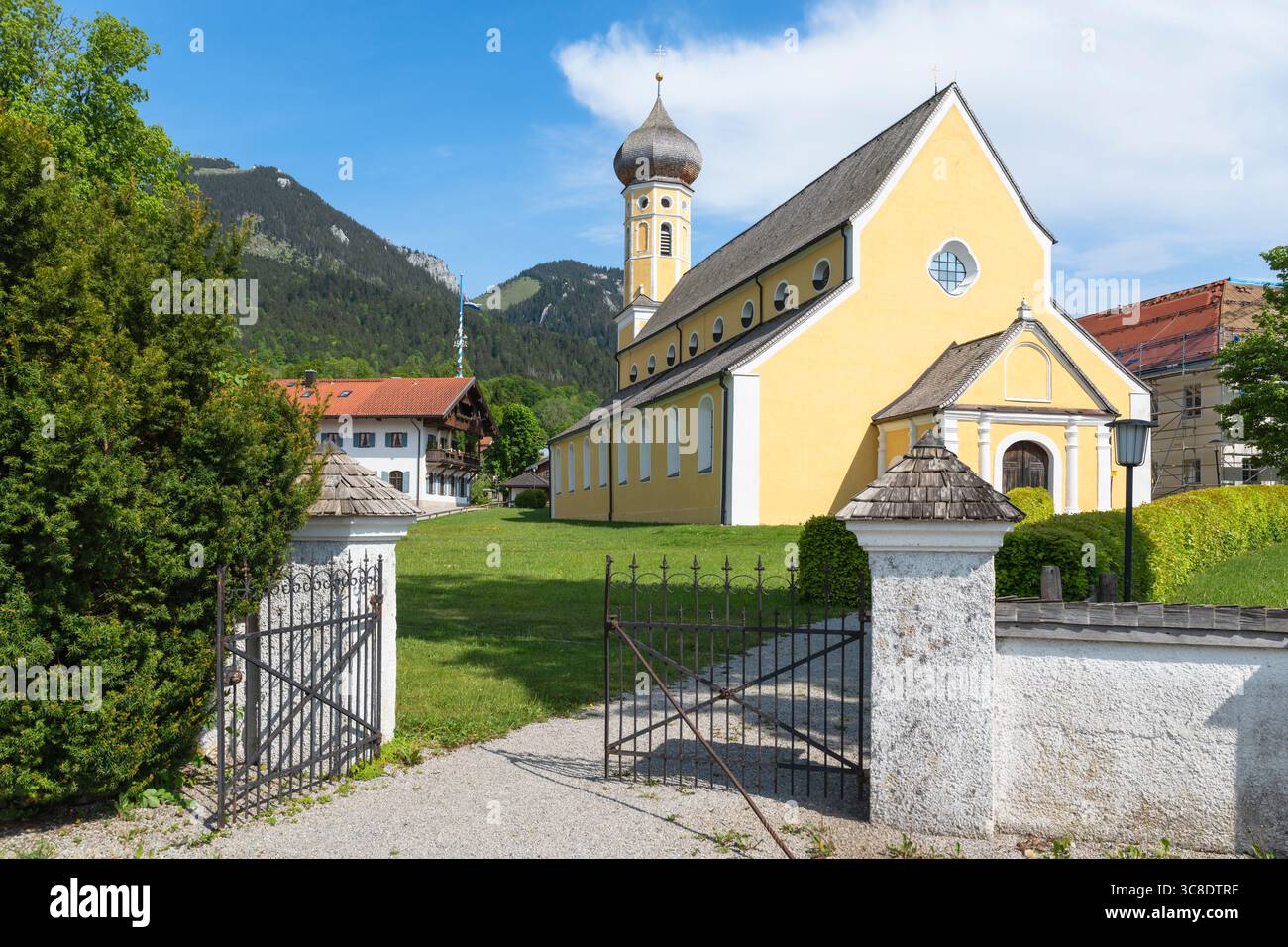 Cancello in ferro battuto all'ingresso del cimitero sulla strada per la chiesa di San Martino a Fischbachau sullo sfondo di una montagna, Baviera, Germania Foto Stock