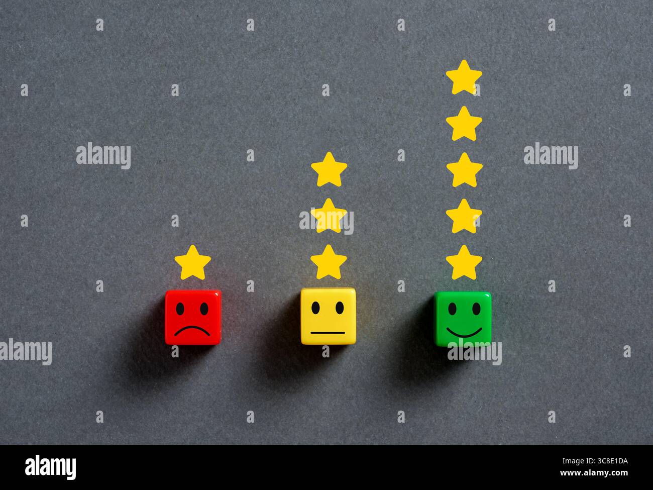 La soddisfazione del cliente sta aumentando con le stelle di valutazione rispetto ai cubi colorati dal rosso per molto insoddisfatto al verde per molto soddisfatto su un dorso grigio Foto Stock