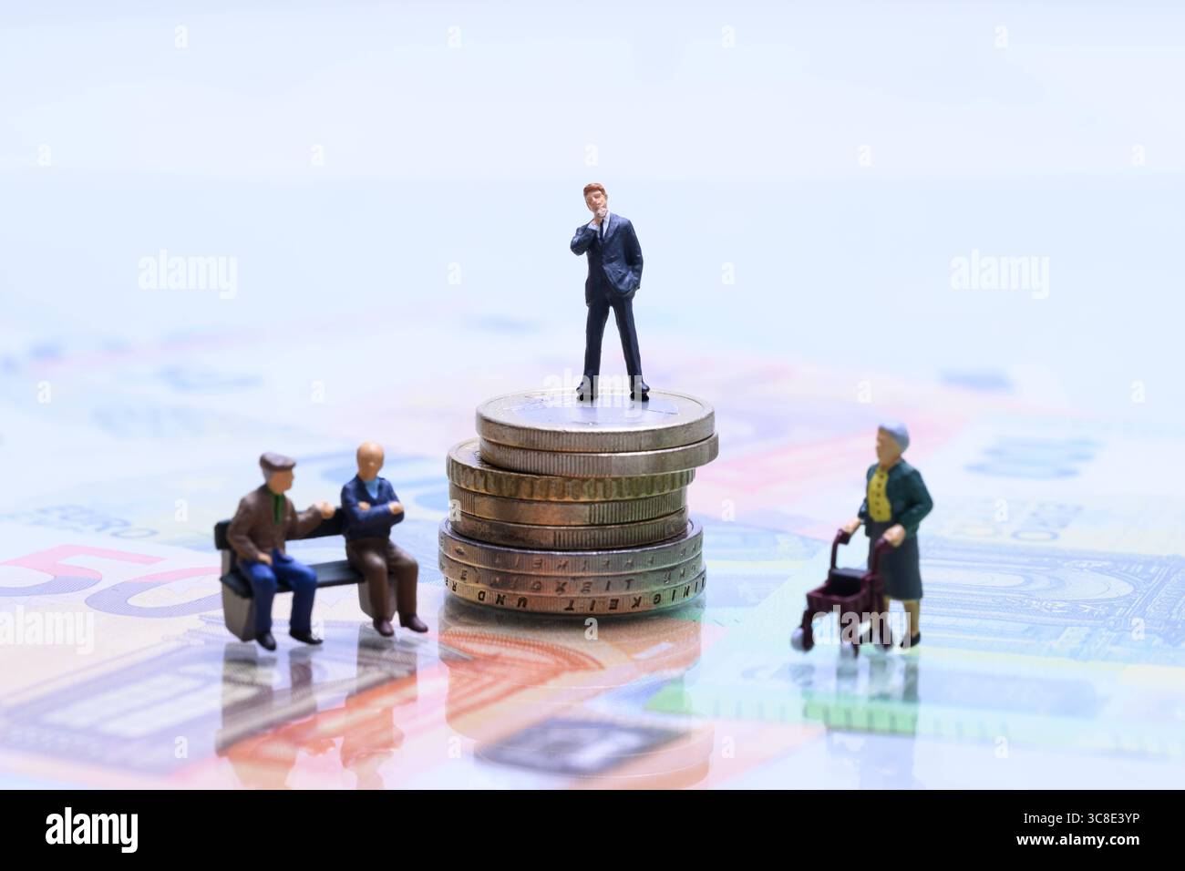 Symbolbild Rentenlücke und Vermögensverteilung Miniaturfiguren auf Münzen und Euroscheinen , Miniatur, Rentner, Senioren, Altersarmut, Rente, Rollator, Pflege, soziale Ungleichheit, Kapital, Geld, Münzen, Euroscheine, Businessfigur, Generationenkonflikt, Vermögensverteilung, Altersvorsorge, Ruhestand, Armut, Reichtum, finanzielle Gerechtigkeit, Wirtschaft, Ungleichverteilung, symbolisch, Gesellschaft, Metapher, Rentenpolitik, Studioaufnahme *** immagine simbolica del divario pensionistico e della distribuzione della ricchezza cifre in miniatura su monete e banconote in euro, miniatura, pensionato, anziano, povertà in vecchiaia, Foto Stock