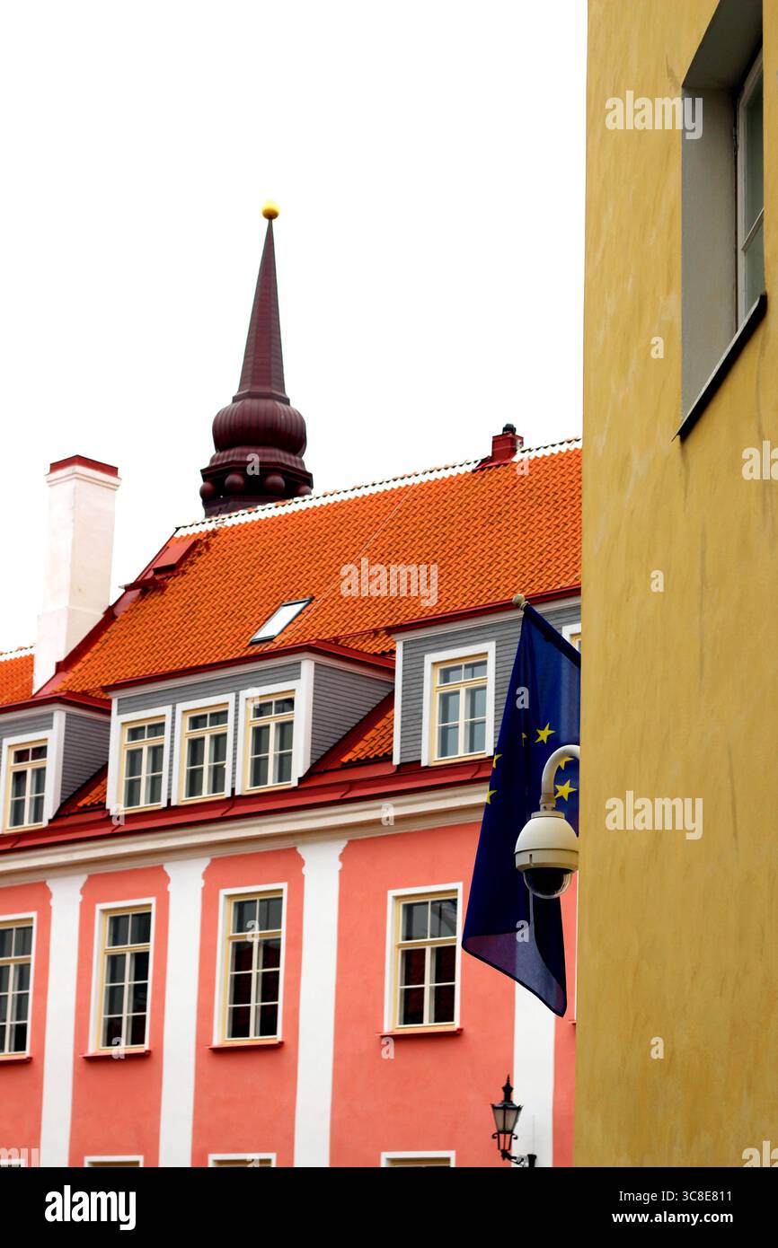 Edificio Riigi Kinnisvara a Tallinn, Estonia, con il suo vibrante esterno rosa e la guglia della Cattedrale di Santa Maria (conosciuta come Chiesa a cupola o Toomkirik) Foto Stock