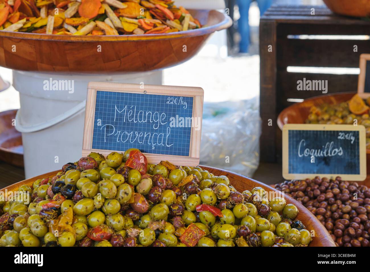 Primo piano di vari tipi di olive sottaceto con erbe aromatiche e olio d'oliva, tra cui il mélange provenzale e il Coquillos in un mercato di Bretenoux Lot in Francia Foto Stock