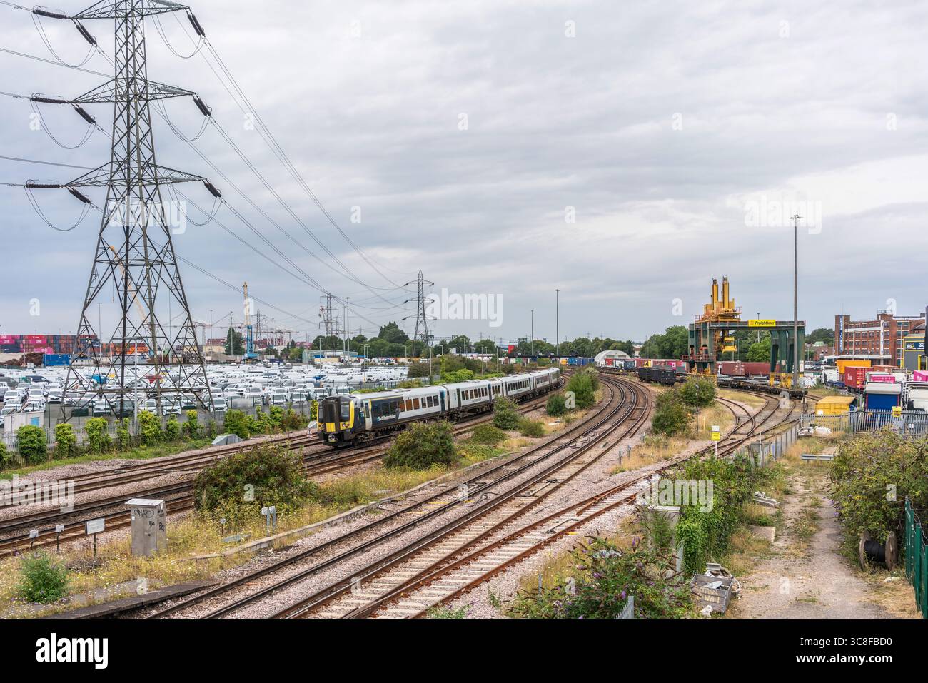 Linee ferroviarie e merci di Southampton nei pressi di Southampton Docks con un treno South Western di passaggio, Southampton, Inghilterra, Regno Unito Foto Stock