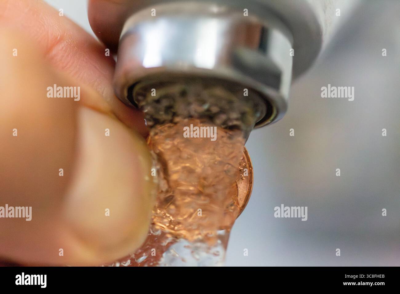 Immagine simbolica del centesimo d'acqua: Una moneta da centesimo sotto l'acqua corrente Foto Stock