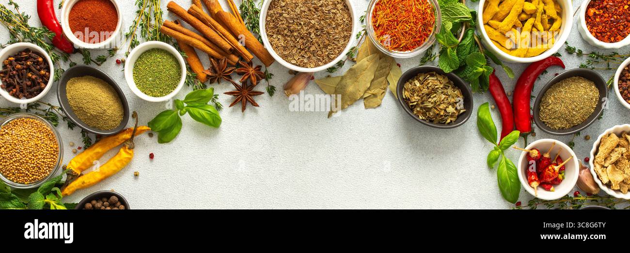 Erbe e spezie colorate e fresche incorniciano uno sfondo grigio, un bordo naturale perfetto per attirare l'attenzione sulla creatività culinaria, vista dall'alto, spazio copia, Foto Stock