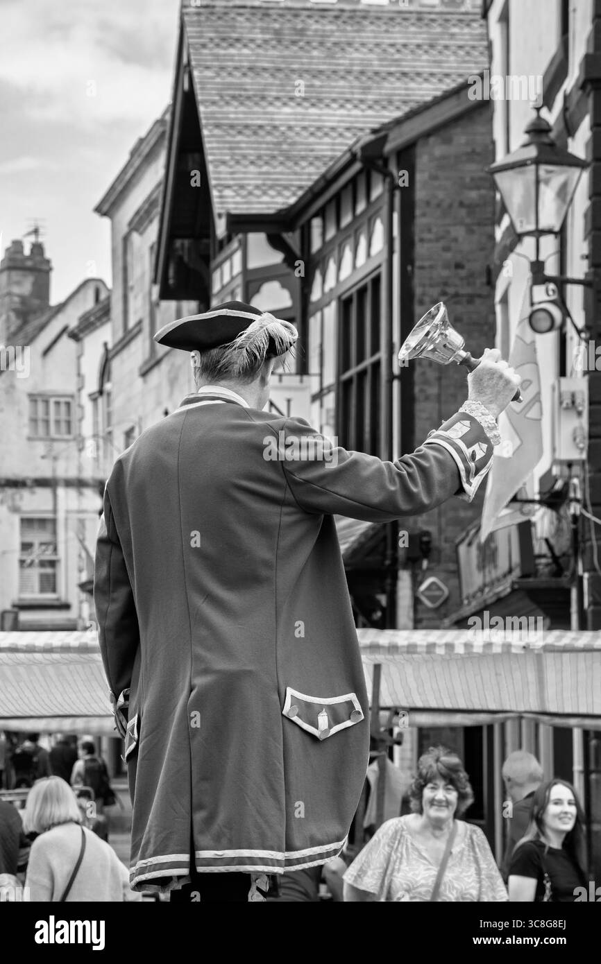 Una cittadina in costume d'epoca suona il campanello in un giorno di mercato, Knaresborough, Yorkshire, Regno Unito. Foto Stock