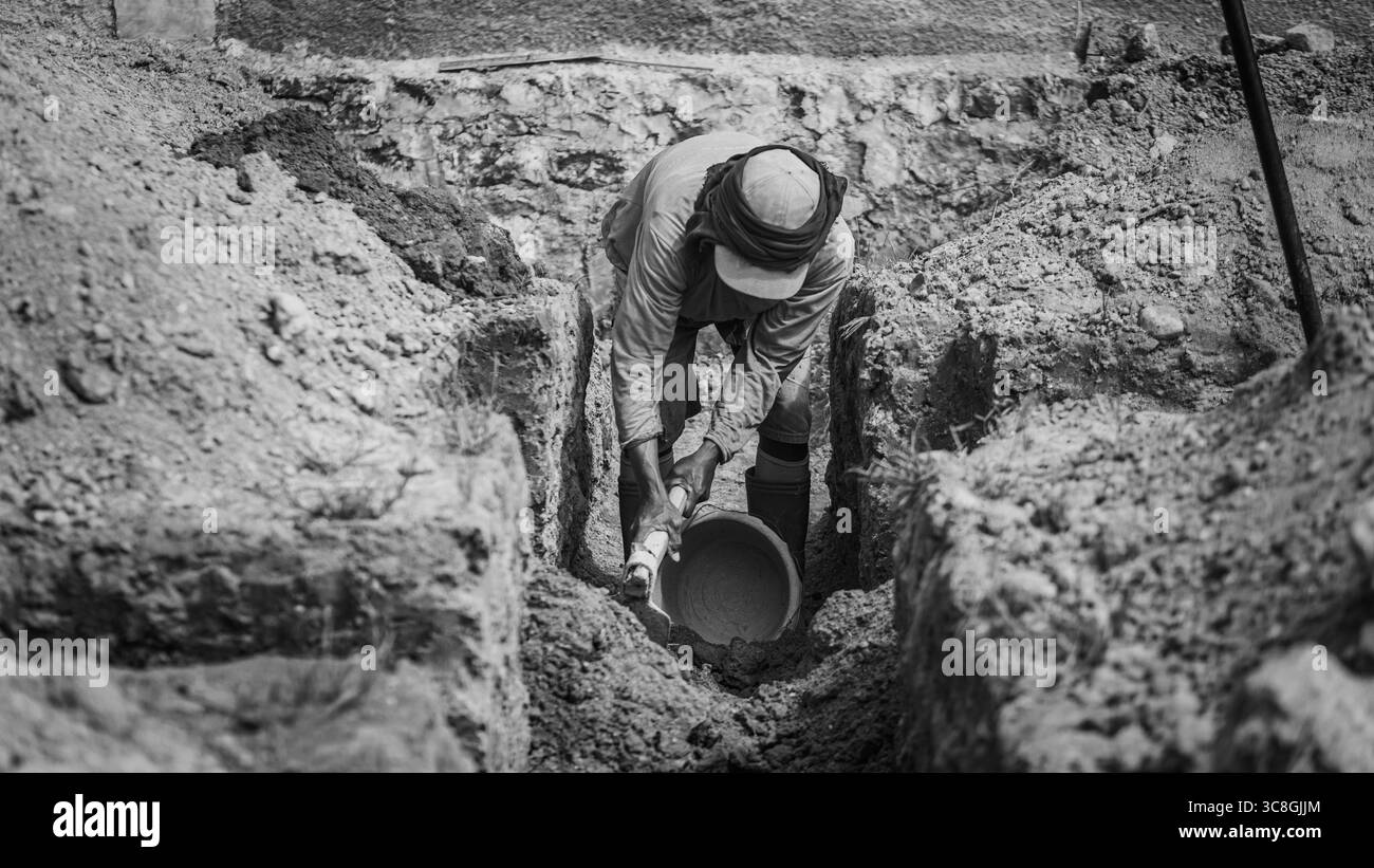 Un lavoratore scava le fondamenta dell'edificio, documentando un processo chiave per la creazione di una costruzione durevole. Foto Stock Un lavoratore scava le fondamenta dell'edificio, documentando un processo chiave per la creazione di una costruzione durevole. Foto Stock