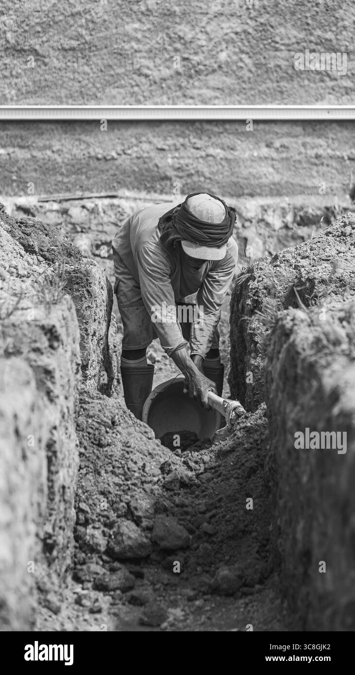 Un lavoratore scava le fondamenta dell'edificio, documentando un processo chiave per la creazione di una costruzione durevole. Foto Stock Un lavoratore scava le fondamenta dell'edificio, documentando un processo chiave per la creazione di una costruzione durevole. Foto Stock