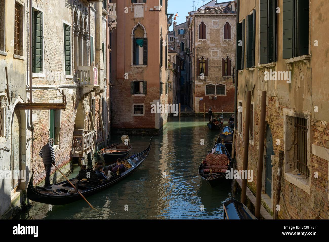 Stretto canale veneziano con gondole ed edifici rinascimentali a Venezia (Venezia), Italia, che mostra l'architettura tradizionale e la vita quotidiana dei canali. Foto Stock