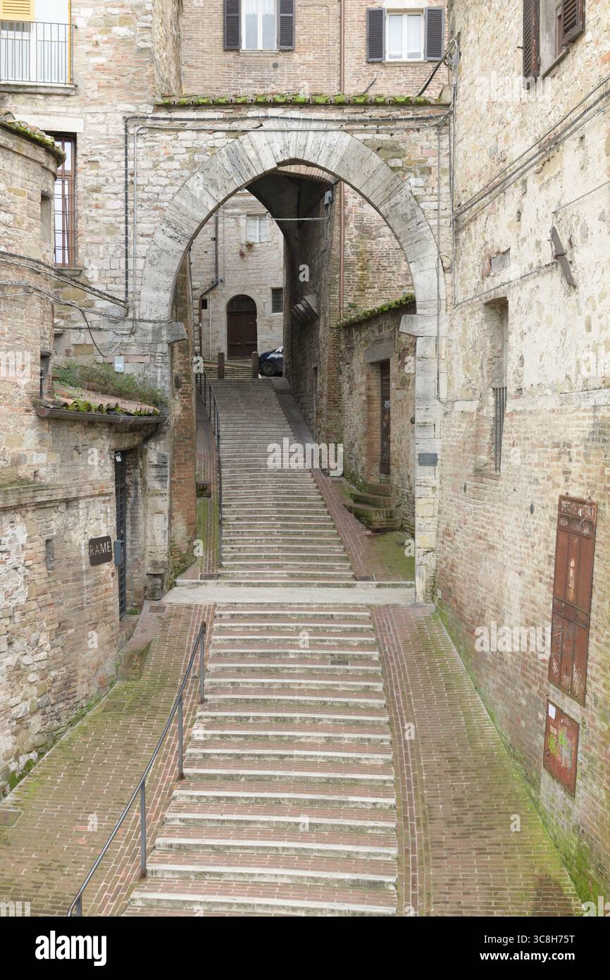 Una stretta via medievale con arco a punta e scalinata nel centro storico di Perugia, Umbria, Italia. Foto Stock