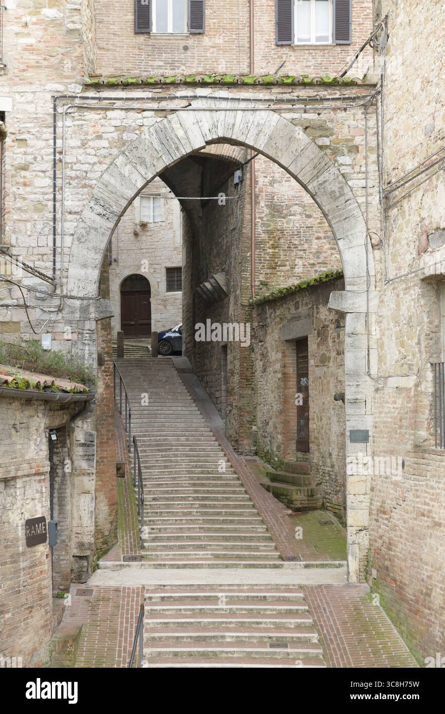 Una stretta via medievale con arco a punta e scalinata nel centro storico di Perugia, Umbria, Italia. Foto Stock