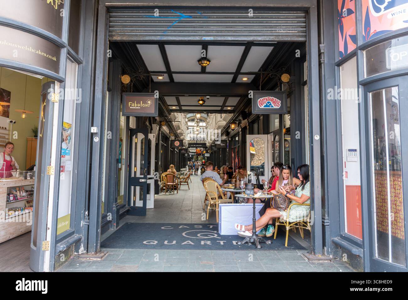 Castle Quarter Arcade a Cardiff, Galles del Sud, Regno Unito, con persone sedute rilassanti e sorseggiate un drink in un giorno d'estate Foto Stock