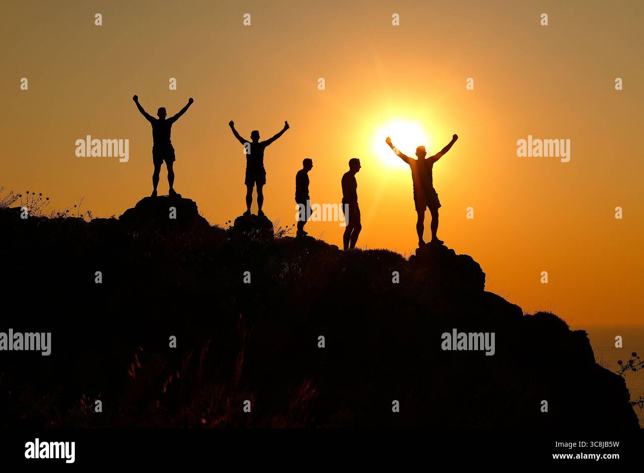 Sagoma di persone su un crinale all'alba a Lindos, Rodi, Grecia. Foto Stock