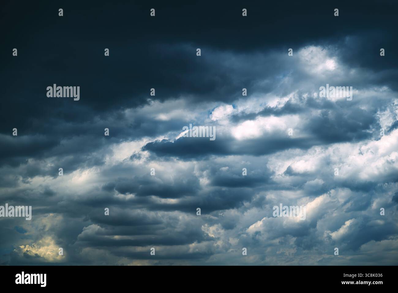 Nuvole di tempesta scure e drammatiche che si formano nel cielo, segnalano un temporale in avvicinamento. Ambientazione meteorologica in condizioni atmosferiche mostruose con una forte copertura delle nuvole e un'atmosfera suggestiva Foto Stock