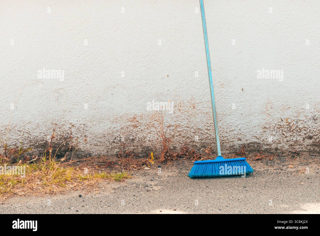 Scopa per pulizia blu contro la vecchia parete come spazio di copia Foto Stock