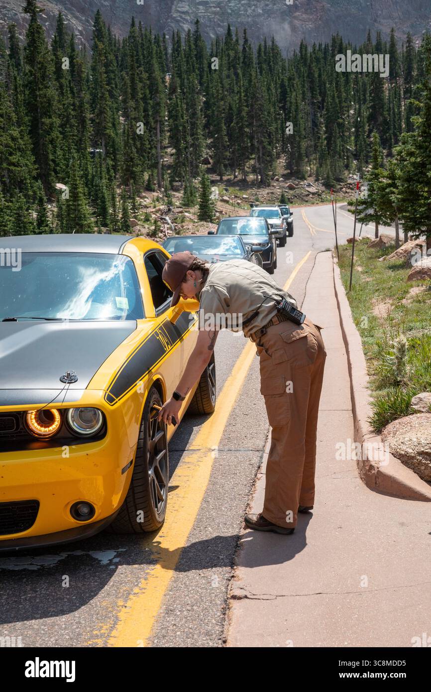 Colorado Springs, Colorado - Un ranger di Pikes Peak controlla la temperatura dei freni su un'auto che scende di 115 metri dal Pikes Peak. Se i freni sono diventati a. Foto Stock