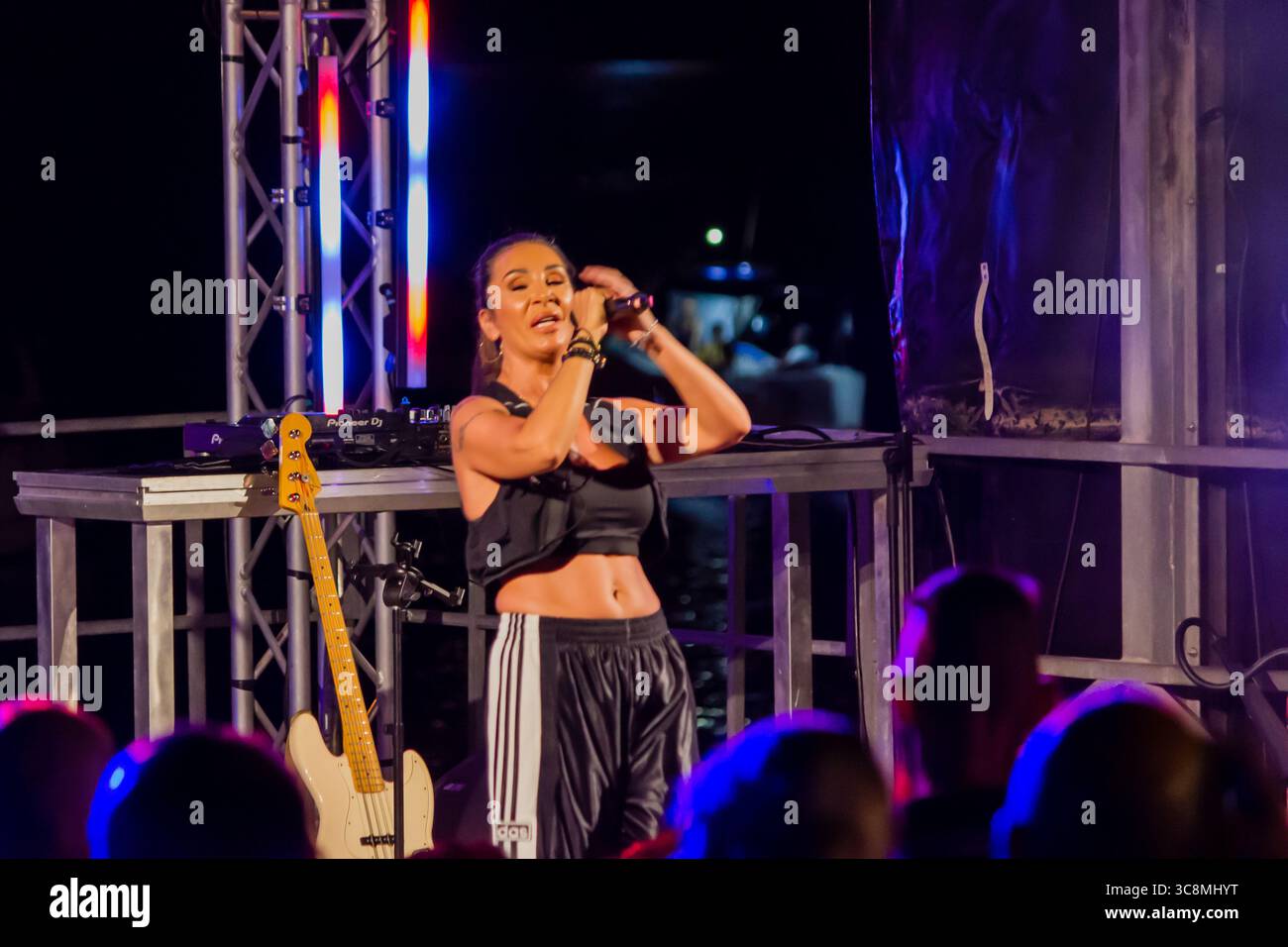 Cantante femminile che si esibisce dal vivo sul palco catturata in un momento dinamico Foto Stock