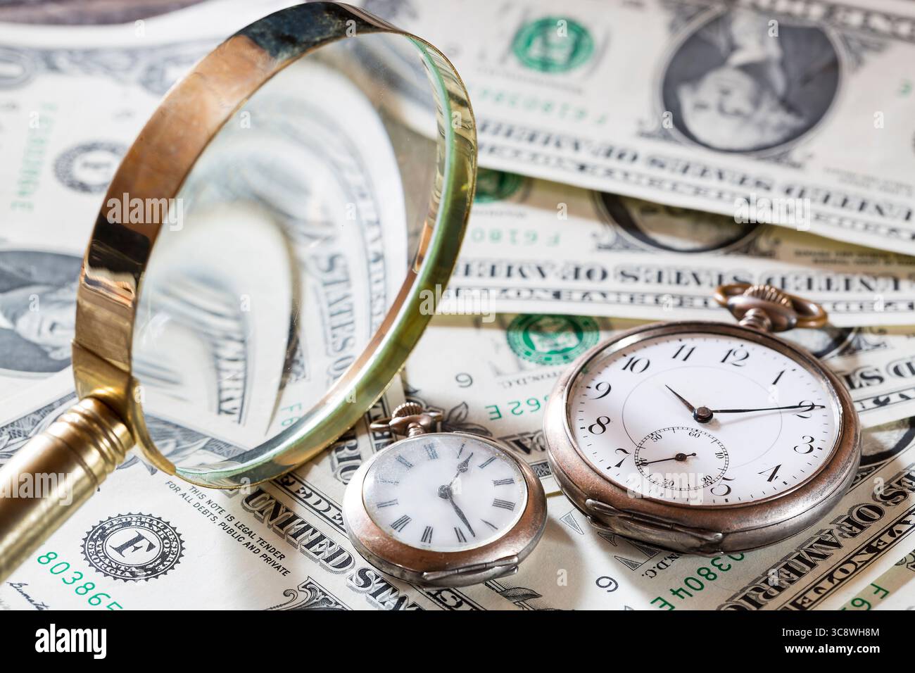 Il tempo è un concetto di finanza con vecchi orologi vintage, banconote da un dollaro e lente d'ingrandimento. Foto Stock
