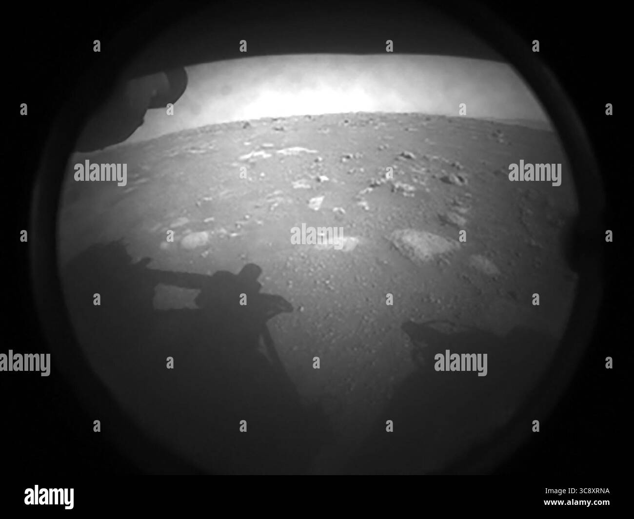 18 febbraio 2021 - Mars Surface - prime immagini il rover di perseveranza della NASA rimandato indietro dopo aver toccato Marte il 18 febbraio 2021. La vista, da una delle telecamere di pericolo di perseveranza, è parzialmente oscurata da una copertura antipolvere. L'ombra del rover può essere vista a sinistra. (Immagine di credito: © JPL-Caltech/NASA/ZUMA Wire/ZUMAPRESS.com) Foto Stock