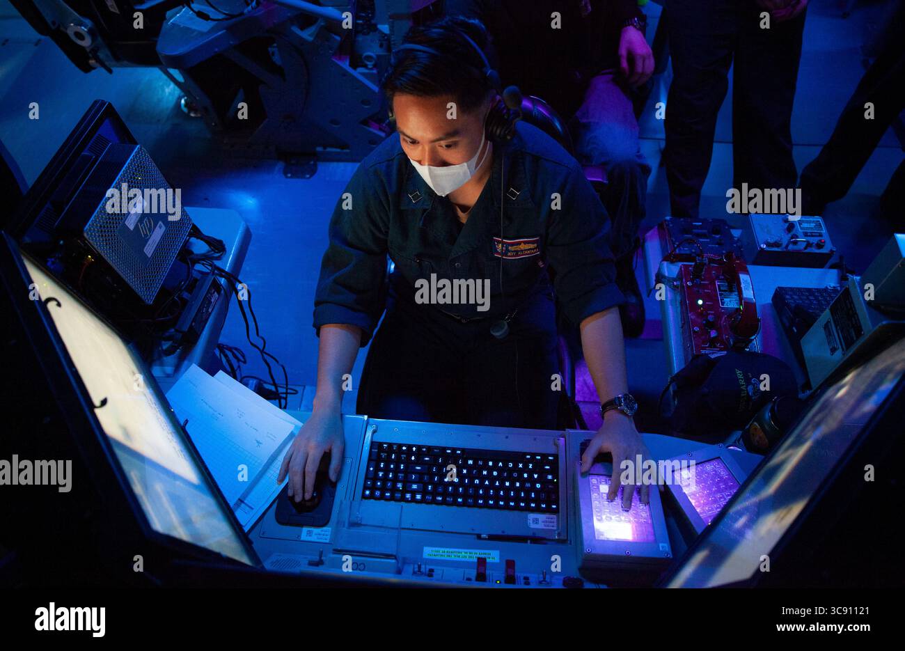 21 febbraio 2021 - Yokosuka, Kanagawa, Giappone - tenente Jeffrey Alcantara, da Los Angeles, CA., l'ufficiale antiterrorismo assegnato al cacciatorpediniere missilistico guidato classe Arleigh-Burke USS Barry (DDG 52), è ufficiale di difesa missilistica balistica (BMD) a guardare nel centro informazioni di combattimento di shipâ durante l'esercitazione bilaterale Resilient Shield 2021. Resilient Shield è un esercizio annuale basato su computer Fleet Synthetic Training-Joint (FST-J) incentrato sulla BMD, progettato per testare le tattiche, le tecniche e le procedure navali degli Stati Uniti (TTP) contro potenziali minacce regionali, garantendo al contempo che le forze giapponesi e statunitensi lo siano Foto Stock