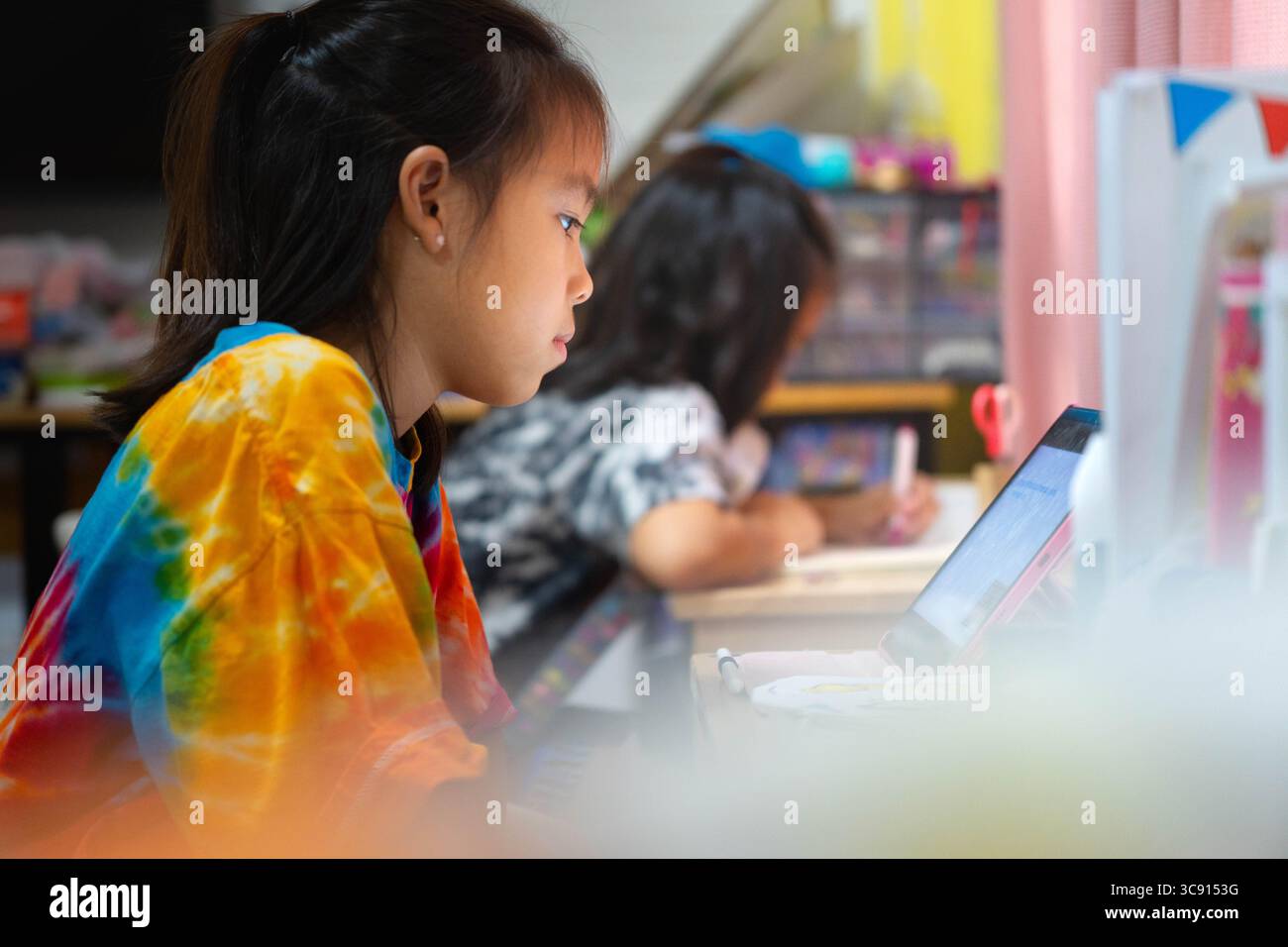 Due studentesse asiatiche studiano a casa, apprendimento a distanza e concetto educativo, fanno i compiti insieme alla scrivania. Foto Stock