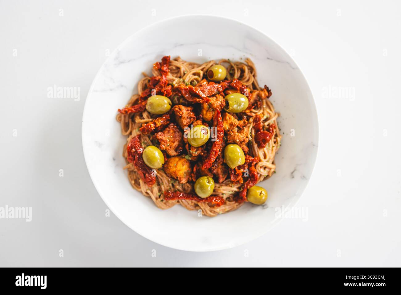 una nutriente ciotola di spaghetti di soba ricoperti da pezzi di teriyaki tofu, pomodori secchi e olive verdi — ideale per sani, a base vegetale e prediabet Foto Stock una nutriente ciotola di spaghetti di soba ricoperti da pezzi di teriyaki tofu, pomodori secchi e olive verdi — ideale per sani, a base vegetale e prediabet Foto Stock