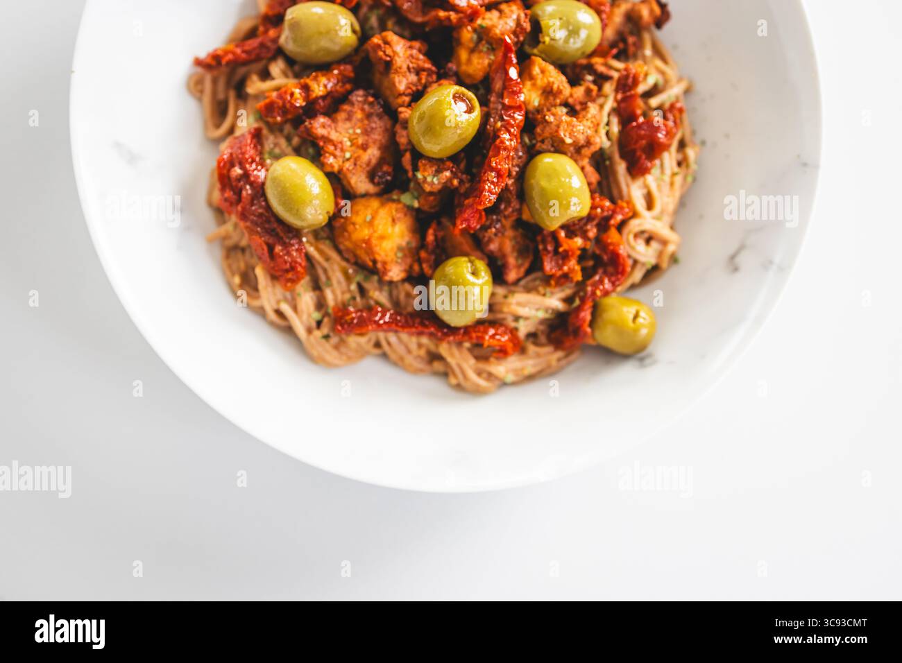 una nutriente ciotola di spaghetti di soba ricoperti da pezzi di teriyaki tofu, pomodori secchi e olive verdi — ideale per sani, a base vegetale e prediabet Foto Stock una nutriente ciotola di spaghetti di soba ricoperti da pezzi di teriyaki tofu, pomodori secchi e olive verdi — ideale per sani, a base vegetale e prediabet Foto Stock